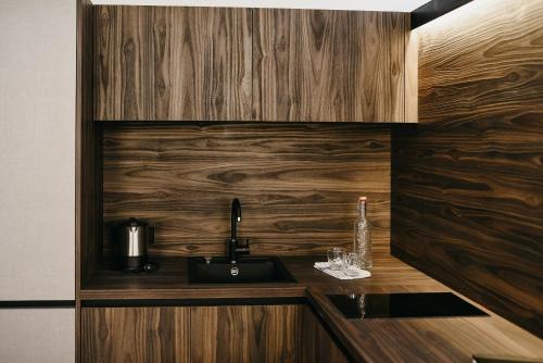 a kitchen with wooden walls and a counter with a sink at Nepomuk rooms in Vipiteno