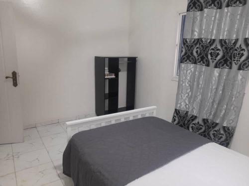 1 Schlafzimmer mit einem Bett, einem Fenster und einem Doppelbett in der Unterkunft Tapis Guest House in Brikama