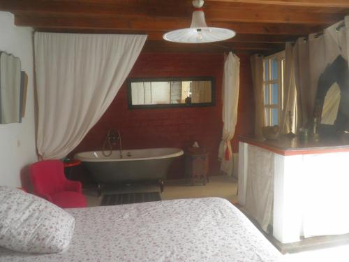 a bedroom with a bathroom with a tub and a bed at La Maison des Artistes in Essaouira