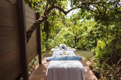 a row of tables sitting on a wooden walkway at Lemala Wildwaters Lodge in Kangulumira