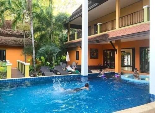 un hombre en una piscina de un hotel en Villa Chaya, en Khao Lak