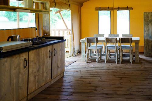 - une cuisine avec une table et des chaises dans la chambre dans l'établissement LE LODGE DU DOMAINE, à Saint-Hilaire-en-Morvan