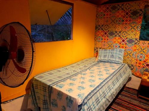 a bedroom with a bed and a fan at Fighting Kangaroo Camp in Dahab