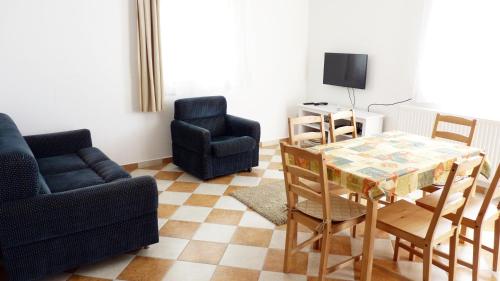 a living room with a table and two chairs at Levendula apartman in Kehidakustány