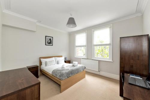 a bedroom with a bed and a desk with a laptop at Derby City Centre, Bright, Spacious, and Airy Apartments - 112 Duffield Road in Derby