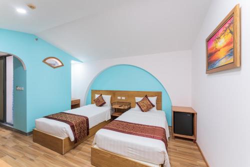 a hotel room with two beds and a tv at Prime New Hotel in Nha Trang