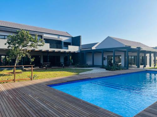 a house with a swimming pool in front of a house at Villa 86, Ballito in Ballito