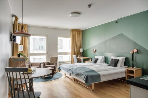 um quarto de hotel com uma cama, uma mesa e cadeiras em Forenom Aparthotel Lund em Lund