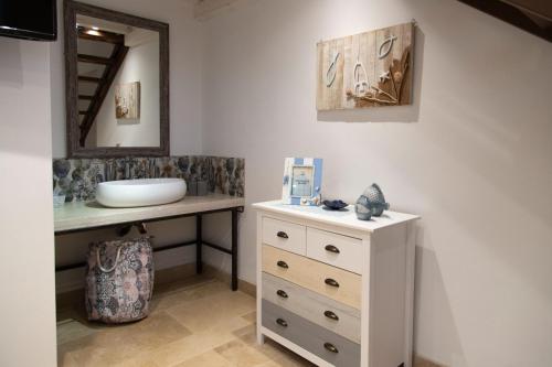 a bathroom with a sink and a white dresser at Il Casale di Punta Prosciutto in Punta Prosciutto