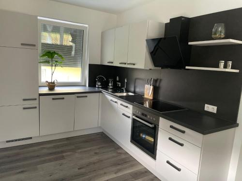 a kitchen with white cabinets and a black counter top at Sorinas Unterkunft WB16 Top 6 
