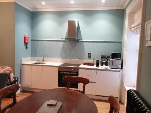 a kitchen with a table and a sink and a stove at Bishop's Gate Hotel in Derry Londonderry