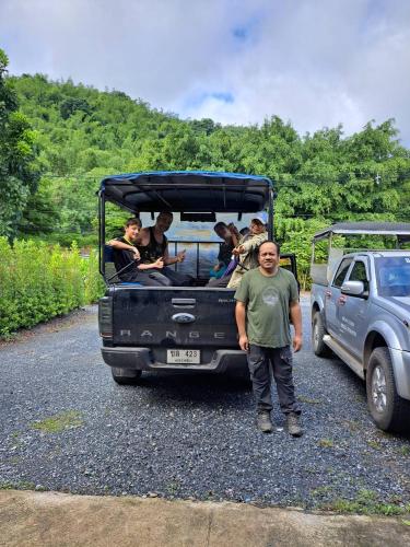 a man standing in front of a truck with people at Sleep private khaoyai in Mu Si