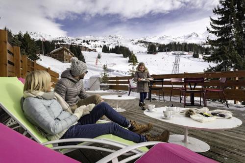 un groupe de personnes assises à une table sur une piste de ski dans l'établissement Belambra Clubs Arc 1800 - Hôtel Du Golf, à Arc 1800