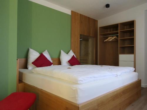 sypialnia z dużym białym łóżkiem z czerwonymi poduszkami w obiekcie Fewo Blick zum Stern w mieście Wermsdorf