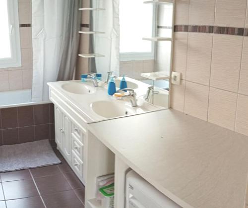 Baño blanco con lavabo y espejo en Chambre #2 dans appartement partagé - Proche des Vosges, en Thann