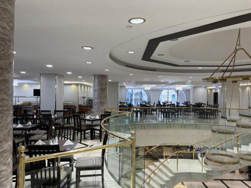 a dining room with tables and chairs in a restaurant at Al Ansar Golden Tulip in Medina