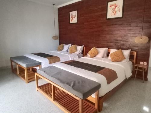 two beds in a room with two tables at THE OWN PENIDA COTTAGE & SPA in Nusa Penida