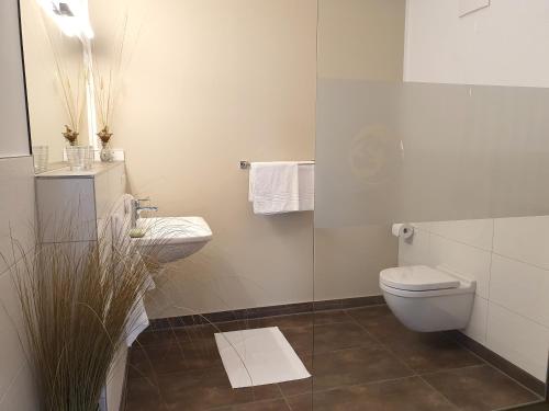 ein weißes Bad mit einem WC und einem Waschbecken in der Unterkunft Villa Camenia in Kühlungsborn