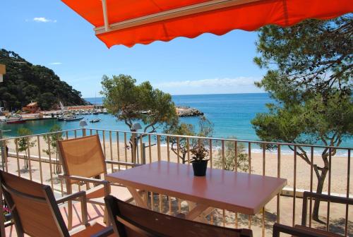 a table on a balcony with a view of the beach at Apto. Plana - 374 in Llafranc