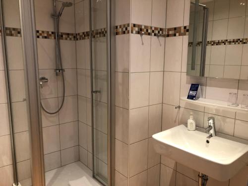 a bathroom with a shower and a sink at Hotel Hubertus Hamacher in Willich