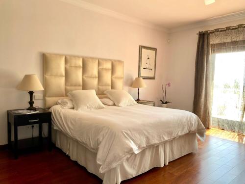 a bedroom with a large white bed and a window at Luxury Villa with Pool in Marbella