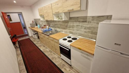 a kitchen with a stove and a white refrigerator at Neiras Apartments Blagaj in Blagaj