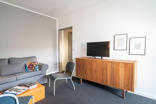 a living room with a couch and a flat screen tv at BIG MAMA Berlin in Berlin