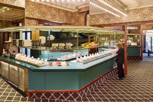 una mujer parada frente a una línea de buffet con comida en Hotel Continental Barcelona, en Barcelona