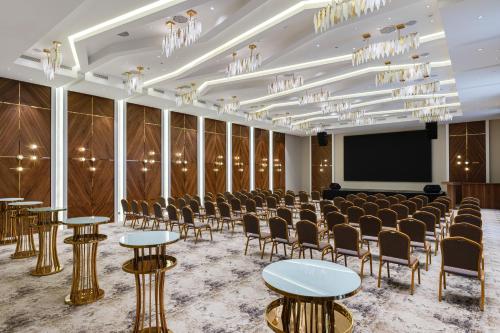 een kamer met stoelen en tafels en een scherm bij Frankfort Hotel and Spa in Tasjkent