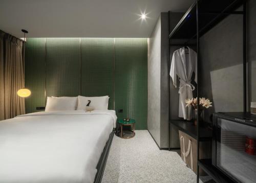 una camera con un grande letto e una parete verde di Goose Living a Bangkok