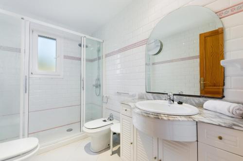 een badkamer met een wastafel, een toilet en een spiegel bij YourHouse Binifat in Andratx