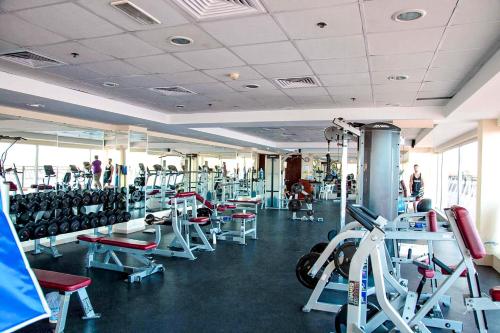 a gym with rows of tread machines and people in it at Sea La View Family Home in Ras al Khaimah