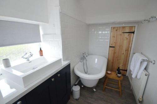 a white bathroom with a sink and a toilet at Old Post Office - Hot Tub, Real Fire, Cumbrian Lakes Coastal Cottage in St Bees