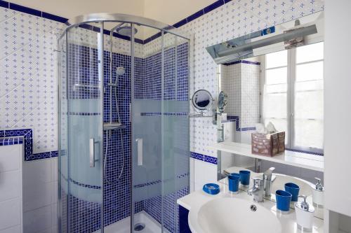 y baño azul y blanco con ducha y lavabo. en Domaine de Seugnac, en Pons