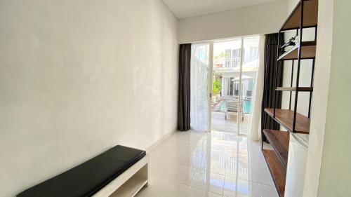 ein Wohnzimmer mit einem Sofa und einem großen Fenster in der Unterkunft Pom Pom's Bali Apartments in Kerobokan