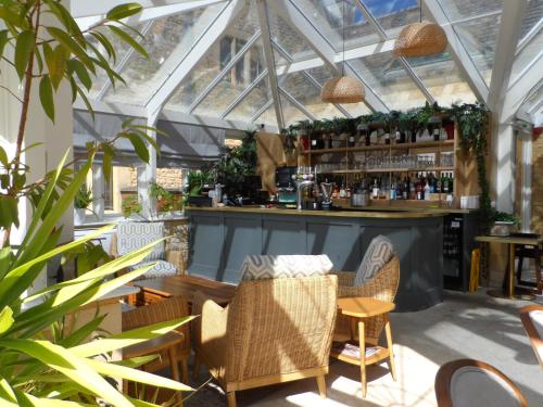 a bar in a greenhouse with chairs and a table at Stanton House Hotel in Swindon