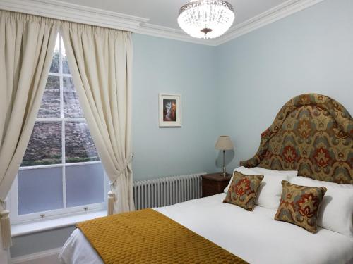 a bedroom with a bed with a large window at Bishop's Gate Hotel in Derry Londonderry