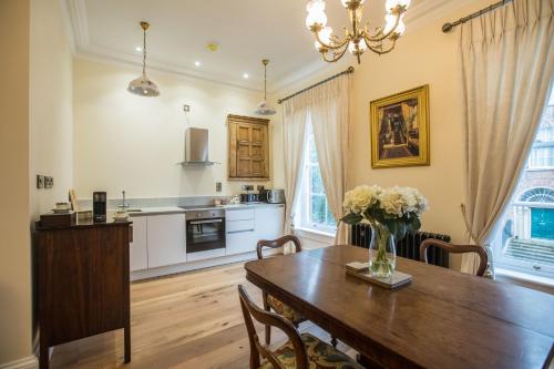 a kitchen and dining room with a wooden table at Bishop's Gate Hotel in Derry Londonderry