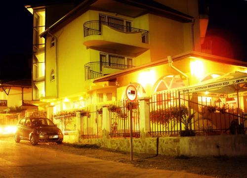 a car parked in front of a building at night at Family Hotel ATLAS in Sinemorets