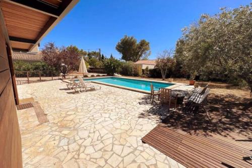 una piscina con sedie e tavolo di PETIT TERME - Piscine - CLIM - Parking a Les Angles Gard