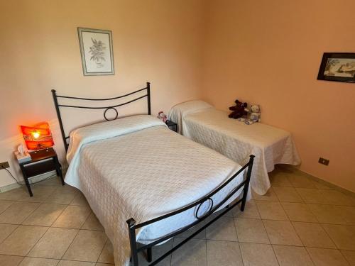 una camera con 2 letti e un pavimento piastrellato di LA CASA IN COLLINA a Veroli