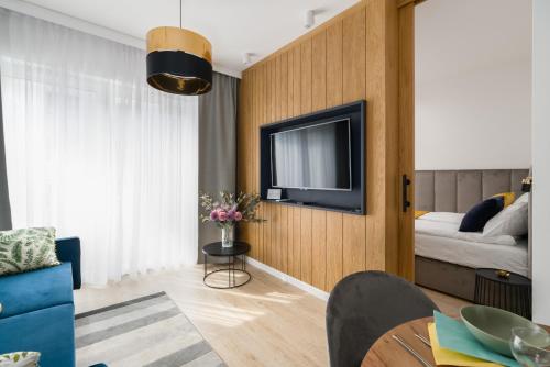 salon z telewizorem i łóżkiem w obiekcie Niedziałkowskiego 25 Apartments Stary Browar City Center by Renters Prestige w Poznaniu