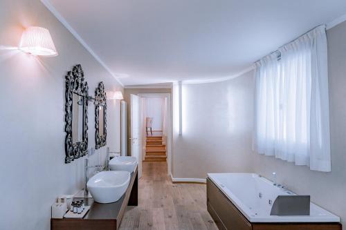a white bathroom with two sinks and a bath tub at TownHouse 33 in Milan
