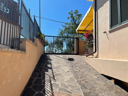 a stone walkway between two buildings with a fence at LA CASA IN COLLINA in Veroli