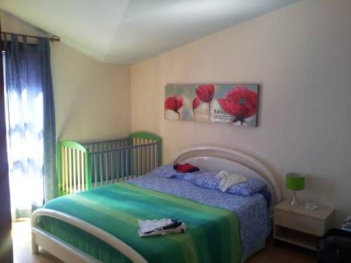 1 dormitorio con 1 cama con manta verde y azul en attico panoramico sul mare, en Santa Maria Navarrese