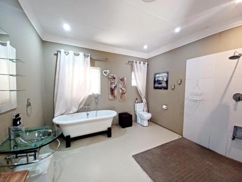 uma casa de banho com uma banheira, um WC e um lavatório. em Casa Cara Guest House em Parys