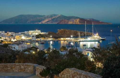 uma vista para um porto à noite com um barco na água em Sirocos em Karavostasi