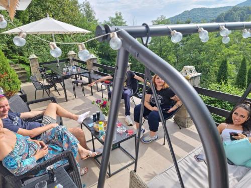 a group of people sitting on a patio at VILA GIGI, ideala pentru relaxare si distractie! in Breaza