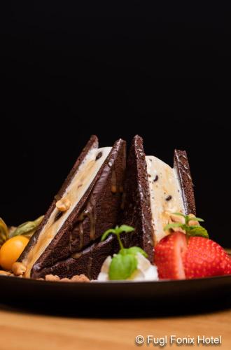 a piece of chocolate cake with a strawberry on a plate at Fugl Fønix Hotel in Etnesjøen