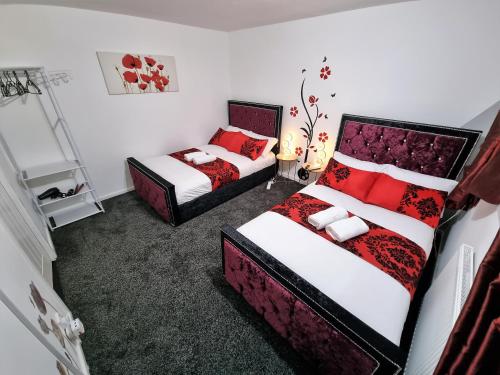 a bedroom with two beds with red pillows at *10OR* Setup for your most relaxed & amazing stay + Free Parking + Free Fast WiFi * in Leeds